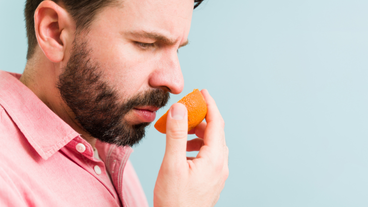 Man sniffing an orange