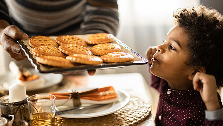 young boy looking at baked cookies